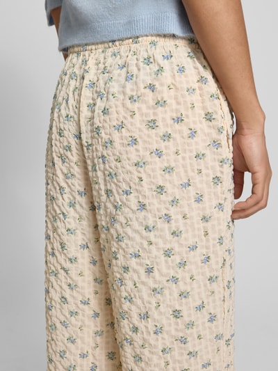 Frauenmodel trägt Wide Leg Pull-on-Hose aus Seersucker mit Kordelzug von REVIEW, Elastischer-Material-Mix, Blumenmuster, Nahaufnahme Oberschenkel.