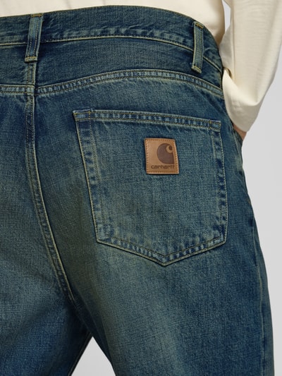 Männermodel trägt Straight Fit Jeans aus reiner Baumwolle Modell 'Aaron' von Carhartt Work In Progress, 5-Pocket, Detailaufnahme, KI-modifiziertes Bild.