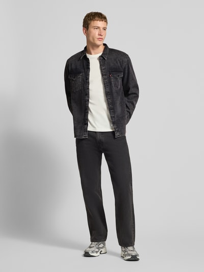 Männermodel trägt Relaxed Fit Jeanshemd mit Brusttaschen Modell 'WESTERN' von Levi's®, schwarze Waschung, Reine Baumwolle, Ganzkörperansicht von vorne.