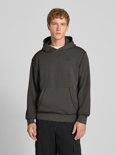 Männermodel trägt Regular Fit Hoodie aus reiner Baumwolle von G-Star RAW in Dunkelgrau, Kängurutasche, einfache Textur, Ganzkörperansicht von vorne.