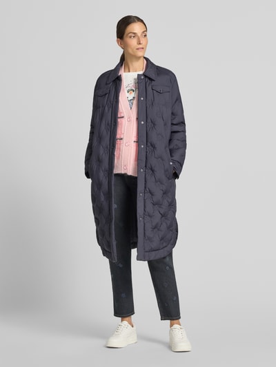 Frauenmodel trägt Oversized Cardigan mit Alpaka-Mohair-Anteil von Marc Cain, rosa, florales Design, grobe Textur, Knopfleiste, Ganzkörperansicht von vorne