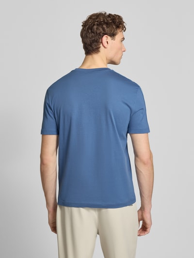 Männermodel trägt T-Shirt mit Label-Patch und Rundhalsausschnitt von EA7 Emporio Armani in Blau, körpernaher Schnitt, Ganzkörperansicht Rückansicht.