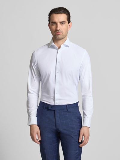 Männermodel trägt Slim Fit Business-Hemd mit Haifischkragen von Seidensticker, Weiß, glatter Material-Mix mit Stretch-Anteil, Knopfleiste, Ganzkörperansicht von vorne. Rückenlänge 76 cm, Schulterbreite 43 cm, Ärmellänge 63 cm bei Größe 40.