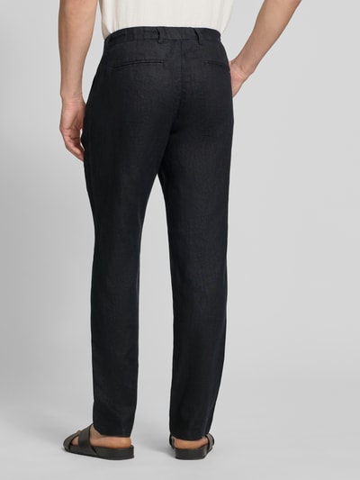 Männermodel trägt Leinenhose mit Eingrifftaschen Modell 'Pandrup' von Casual Friday, Regular Fit, dunkler Stoff, Ganzkörperansicht Rückansicht.