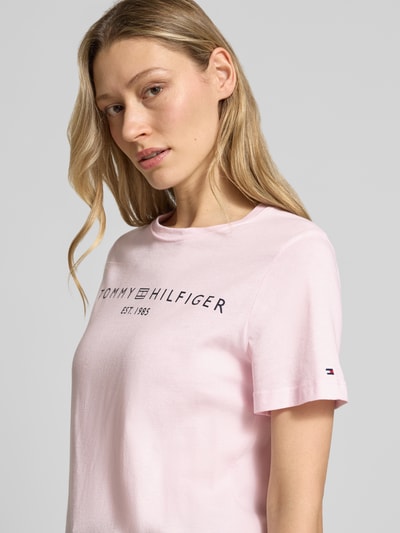 Frauenmodel trägt Regular Fit T-Shirt aus reiner Baumwolle von Tommy Hilfiger in Optik: Unifarben mit Logo-Detail, Label-Schriftzug, Rundhals, Kurzarm, Materialverarbeitung: Jersey, Nahaufnahme Oberkörper.