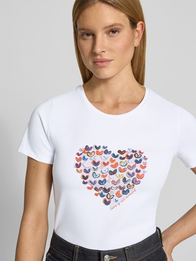 Vrouwenmodel draagt t-shirt met motiefprint van More & More, wit, mix van katoen en elastaan, regular fit, ronde hals, ruglengte maat 36: 60 cm, vooraanzicht bovenlichaam