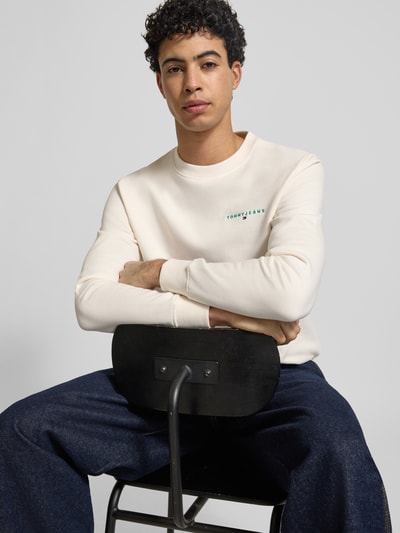 Männermodel trägt Regular Fit Sweatshirt aus katoenmix Model 'LINEAR CREW' van Tommy Jeans in effen kleuren met labelstitching applicatie, ronde hals en geribde mouw- en rompzoom, sweatmateriaal, Nahaufnahme Oberkörper.