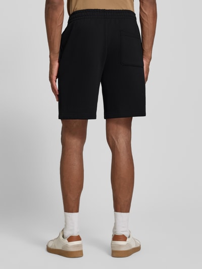 Mężczyzna nosi Regular Fit Sweatshorts aus Baumwoll-Mix od Lacoste, czarny kolor, miękka tekstura, jednolity, Ganzkörperansicht Rückansicht.