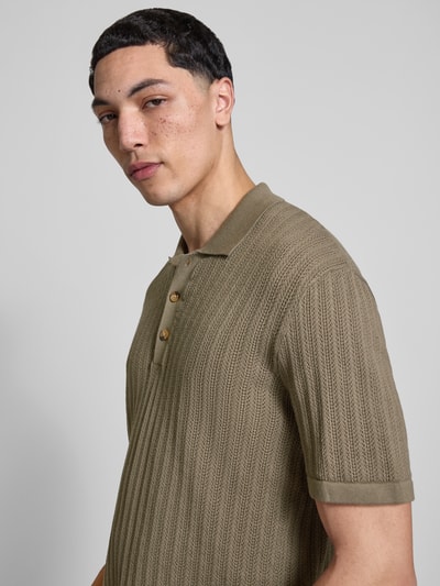 Männermodel trägt Regular Fit Poloshirt aus Baumwoll-Mix Modell 'MOON' von Only & Sons in Strickoptik, Strukturmuster, Nahaufnahme Oberkörper.