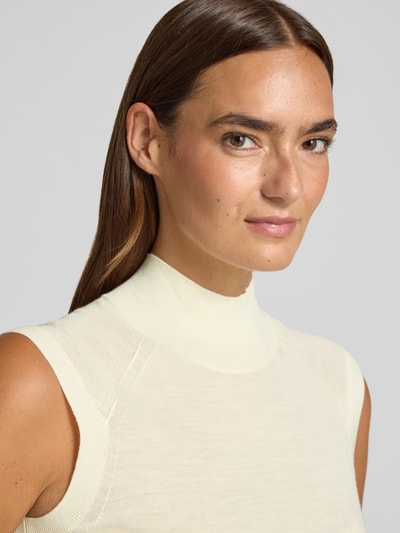 Frauenmodel trägt Slim Fit Pullunder aus reiner Schurwolle Modell 'FIPINI' von BOSS in Creme, feine Stricktextur, Nahaufnahme Oberkörper, Damen.