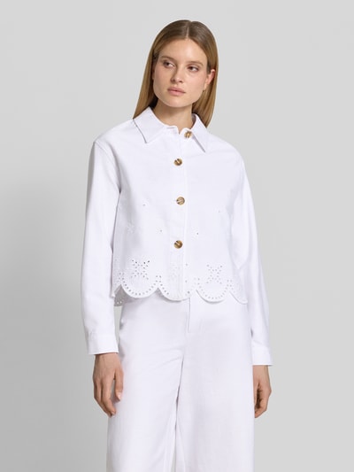 Frauenmodel trägt Jacke mit Lochstickerei Modell 'Marietta' von GUIDO MARIA KRETSCHMER WOMAN aus weißer Baumwolle, gerader Schnitt, Hemdblusenkragen, Knopfleiste, Lochmuster, Ganzkörperansicht von vorne.