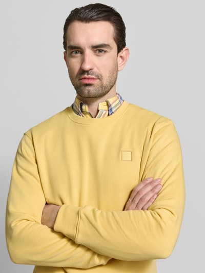 Männermodel trägt Sweatshirt mit Rundhalsausschnitt von Scotch & Soda, Reine Baumwolle, Regular-Fit, Label-Stitching, Nahaufnahme Oberkörper.