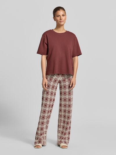 Frauenmodel trägt Flared Cut Hose im Allover-Look Modell 'JASPER' von SUNCOO PARIS aus Viskose-Mix mit elastischem Bund, Ganzkörperansicht von vorne.