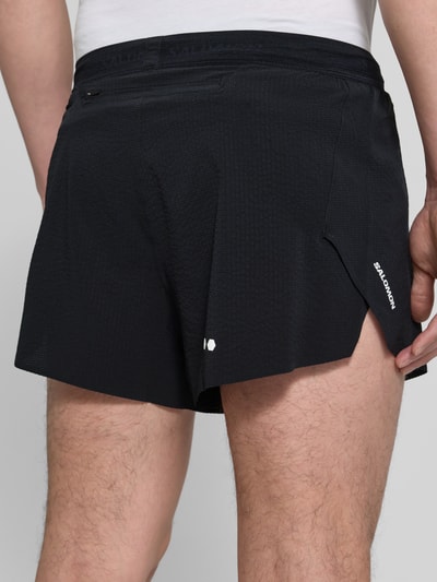Männermodel trägt Shorts mit elastischem Bund Modell 'SENSE AERO' von Salomon aus schwarzem Material-Mix mit Stretch-Anteil, Regular-Fit, Ganzkörperansicht Rückansicht.