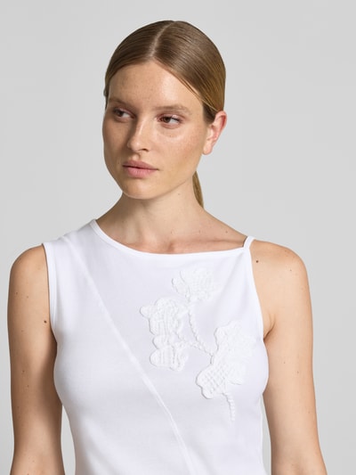 Frauenmodel trägt Regular Fit Top aus reiner Baumwolle Modell 'BAGAGLI' von MAX&Co., weiß, florale Stickerei, Nahaufnahme Oberkörper.