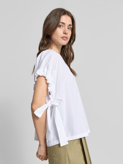 Frauenmodel trägt Relaxed Fit Bluse mit V-Ausschnitt von Marc Cain in Weiß, reine Baumwolle, Raffungen, kurzärmelig, Nahaufnahme Oberkörper.