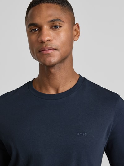 Mannelijk model draagt T-shirt uit katoen model 'Thompson' van BOSS met subtiele logo-print, donkerblauw, rechte pasvorm, Nahaufnahme bovenlichaam.