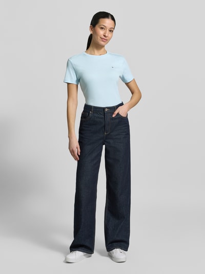 Frauenmodel trägt Slim Fit T-Shirt aus reiner Baumwolle von Tommy Hilfiger, Optik: Unifarben, Logo-Stitching, Rundhals, Kurzarm, Jersey, Damen T-Shirt, Ganzkörperansicht von vorne.
