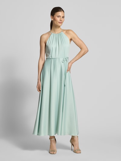 Frauenmodel trägt Cocktailkleid aus Satin mit Bindegürtel von Jake*s Cocktail, A-Linie, hellgrün, Neckholder, fließende Struktur, Ganzkörperansicht von vorne