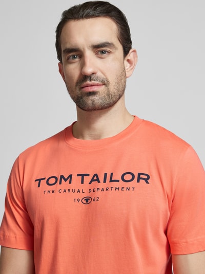 Männermodel trägt Regular Fit T-Shirt aus reiner Baumwolle von Tom Tailor in Unifarbe mit Label Print, Rundhals, Nahaufnahme Oberkörper.