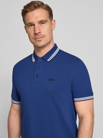 Männermodel trägt Regular Fit Poloshirt aus reiner Baumwolle Modell 'PADDY' von BOSS Green, unifarben, Nahaufnahme Oberkörper.