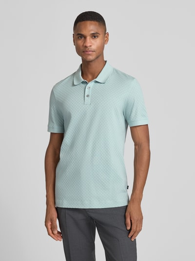 Männermodel trägt Poloshirt mit kurzer Knopfleiste Modell 'Roni' von JOOP! Collection in Mintgrün, reine Baumwolle, Regular Fit, Ganzkörperansicht von vorne.
