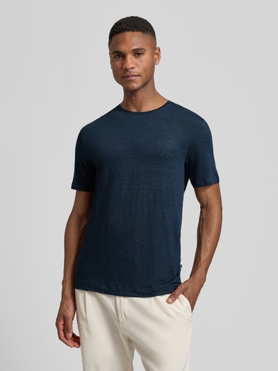 Mannelijk model draagt T-shirt uit mix van linnen en elastaan met ronde hals van OLYMP Level Five, regular fit, labeldetail, ruglengte bij maat M: 69 cm, voorkant torso dicht bij opname.