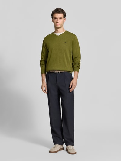 Männermodel trägt Strickpullover mit Label-Strickerei von Fynch-Hatton, reine Baumwolle, V-Ausschnitt, Ganzkörperansicht von vorne.
