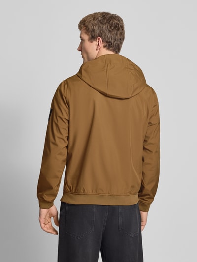 Mannenmodel draagt Softshelljacke mit Reißverschlusstaschen van Jack & Jones in bruin, regular fit, capuchon, rugaanzicht.