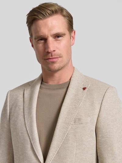 Männermodel trägt Slim Fit 2-Knopf-Sakko mit Reverskragen von Roy Robson, mieszanka bawełny, nakładane kieszenie, krój slim fit, długość tyłu 74 cm, szerokość ramion 43 cm, długość rękawów 67 cm, beżowy, prążkowana tekstura, Nahaufnahme górnej części ciała.