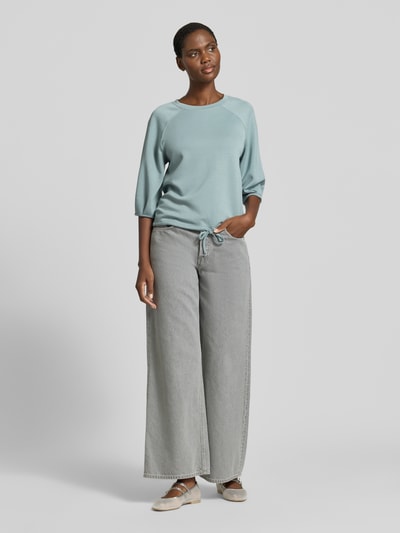 Frauenmodel trägt Sweatshirt mit 3/4-Arm und Tunnelzug von Zero, aus Material-Mix mit Viskose-Anteil, Regular-Fit, Rundhalsausschnitt, sanftes Hellblau, matte Textur, kombiniert mit grauer Wide-Fit-Hose, Ganzkörperansicht von vorne.