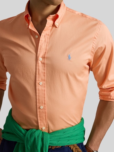 Männermodel trägt Regular Fit Freizeithemd aus reiner Baumwolle von Polo Ralph Lauren in effen oranje twill, met button-down kraag, logo-stiksel, lange mouw en sportmanchet, Nahaufnahme Oberkörper.
