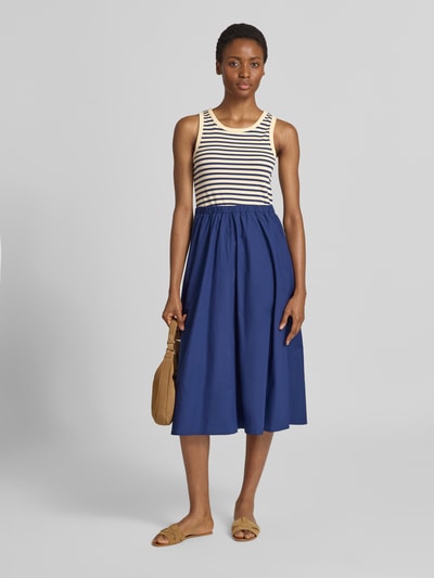 Frauenmodel trägt Tailliertes Freizeitkleid aus Baumwoll-Mix von s.Oliver RED LABEL mit gestreiftem Oberteil, unifarbenem blauen Rock, Ganzkörperansicht von vorne.