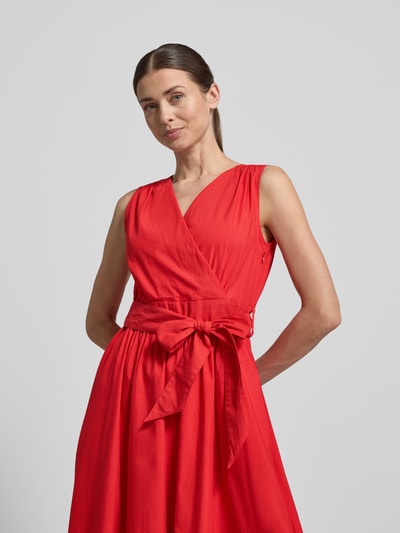 Frauenmodel trägt Midikleid mit V-Ausschnitt und Bindegürtel von ROBE LÉGÈRE aus Baumwoll-Mix, A-Linie, leuchtend rot, Nahaufnahme Oberkörper. Rückenlänge bei Größe 36: 117 cm, Brustweite bei Größe 36: 36 cm.
