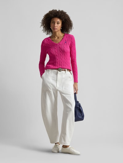 Vrouwenmodel draagt Regular Fit Strickpullover aus Woll-Kaschmir-Mix van Polo Ralph Lauren in effen roze met kabelpatroon, logo-stiksel, ronde hals, lange mouwen, geribde boorden, breisel textuur; volledige frontale lichaamsopname.