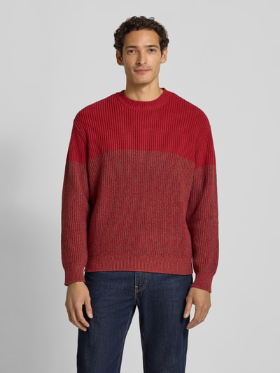 Männermodel trägt Strickpullover mit Rundhalsausschnitt von Armani Exchange, rot, Grobstrick, Baumwoll-Mix, Regular Fit, Ganzkörperansicht von vorne.