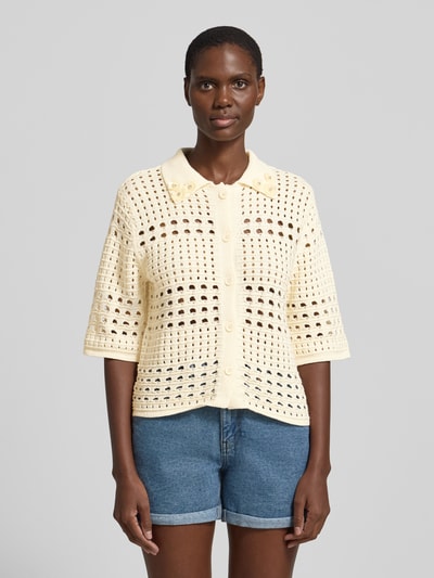 Frauenmodel trägt Regular Fit Bluse in Strick-Optik mit floralem Ziersteinbesatz von Liu Jo White aus Reiner Baumwolle, Halbarm, Umlegekragen, durchgängiger Knopfleiste und Lochmuster, cremefarben, Ganzkörperansicht von vorne.