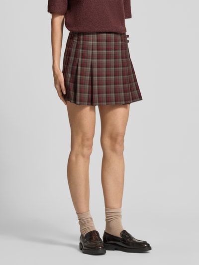 Frauenmodel trägt Minirock mit Falten Modell 'PUNK' von MANGO im Allover-Karo-Look, Material-Mix mit Viskose, A-Linie, Nahaufnahme Unterkörper.