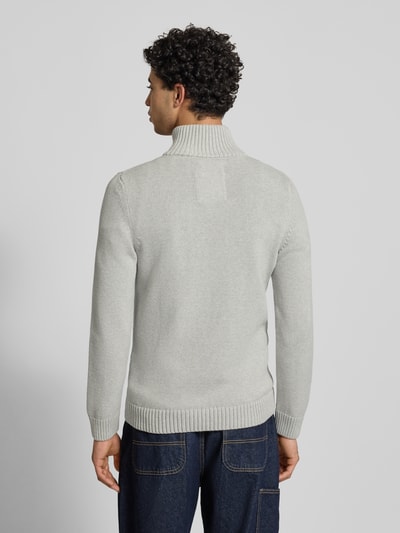 Męski model nosi Slim Fit Pullover in Strick-Optik od Superdry, stójka, zamek błyskawiczny, wyhaftowane logo, imitacja dzianiny, krój slim fit, długość tyłu w rozmiarze M: 70 cm, długość rękawa w rozmiarze M: 65 cm, widok całej sylwetki z tyłu.