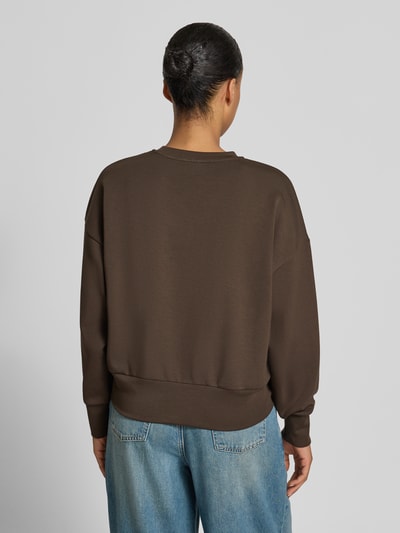 Frauenmodel trägt Oversized Sweatshirt aus Viskose-Mix Modell 'Nima' von MOS MOSH, braun, elastische Abschlüsse, Ganzkörperansicht Rückansicht.