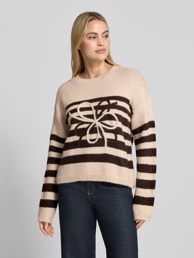 Modelka nosi Strickpullover im Allover-Look mit Rundhalsausschnitt von MORE & MORE w kolorach beżowym i brązowym, wzór paski i motyw, relaxed fit, oversize ramiona, długość tyłu 53 cm, długość rękawa 53 cm, widok całej sylwetki z przodu.