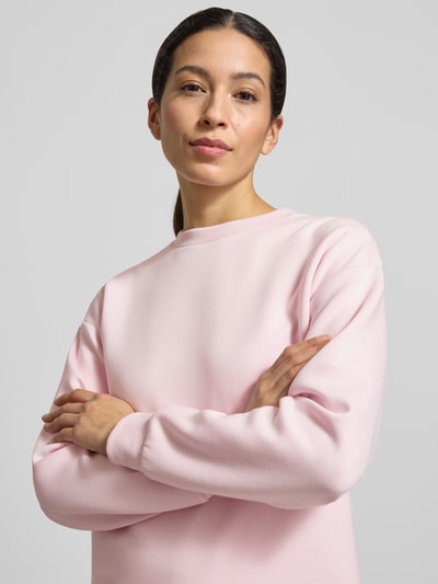 Vrouwenmodel draagt Regular Fit Sweatshirt uit viscose-mix model 'Sandy' van Vila, lichtroze, ronde hals, elastische boorden, close-up bovenlichaam.