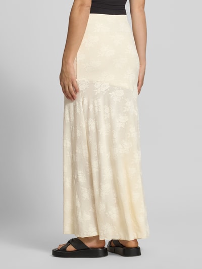 Frauenmodel trägt Maxirock mit elastischem Bund von Gina Tricot, Material-Mix mit Stretch-Anteil, Gerader-Schnitt, Embroidery Design, sanfte Cremefarbe, florale Textur, Damen, Ganzkörperansicht Rückansicht.