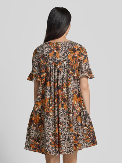 Frauenmodel trägt A-Linien Kaftankleid aus reiner Baumwolle Modell 'FUOCO' von Weekend Max Mara mit Allover-Muster in Orange und Schwarz, kurze Volantärmel, Jersey-Stoff, Ganzkörperansicht Rückansicht.