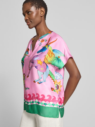Frauenmodel trägt Blusenshirt aus Viskose im Allover-Look von Milano Italy in Rosa mit buntem Einhornmotiv, Regular-Fit, V-Ausschnitt, Ganzkörperansicht von vorne, Rückenlänge bei Größe 36: 64 cm, Ärmellänge bei Größe 36: 20 cm.