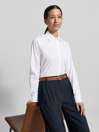 Frauenmodel trägt Regular Fit Hemdbluse aus reiner Baumwolle Modell 'ESSENTIAL' von HUGO, unifarben weiß, Popeline, Langarm, Knopfleiste, Ganzkörperansicht von vorne.
