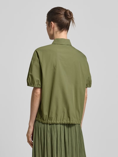 Frauenmodel trägt Regular Fit Bluse mit Polokragen von Marc Cain in Olivgrün, elastische Ärmel, Baumwolle, Rückansicht, Ganzkörperansicht.