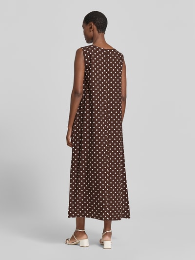 Frauenmodel trägt Midikleid aus Viskose-Mix mit Eingrifftaschen Modell 'Lavisco' von FREE/QUENT, braun mit weißen Punkten, Ganzkörperansicht Rückansicht.