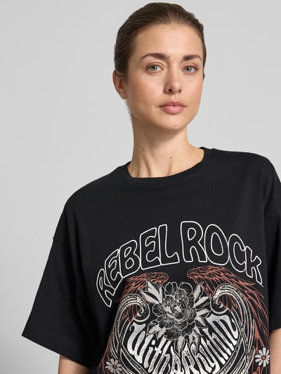 Frauenmodel trägt Oversized T-Shirt aus reiner Baumwolle Modell 'LILIE' von Vero Moda, Optik: Unifarben, Motiv-Print, Kurzarm, Nahaufnahme Oberkörper.