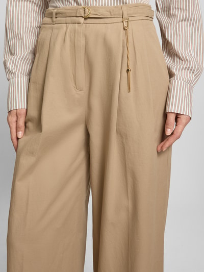Frauenmodel trägt Straight Fit Hose aus reiner Baumwolle von HUGO, Optik: Unifarben, Passform: Straight, goldener Karabiner-Anhänger, seitliche Eingrifftaschen, Nahaufnahme Oberkörper.